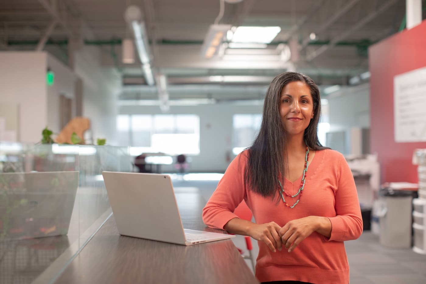 A marketer at a standing desk in a bright office, laptop open
