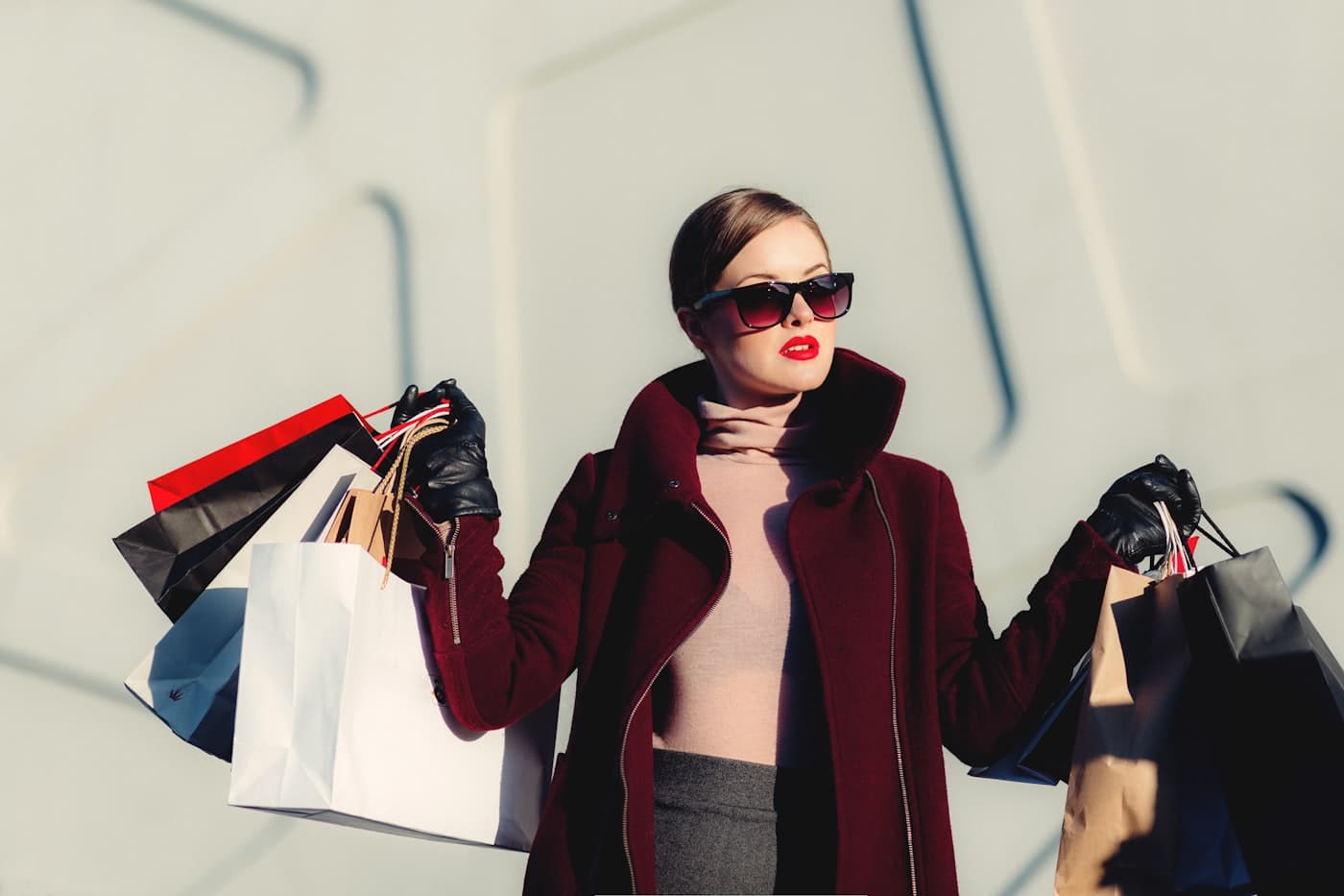 A shopper in sunglasses carrying an armful of shopping bags
