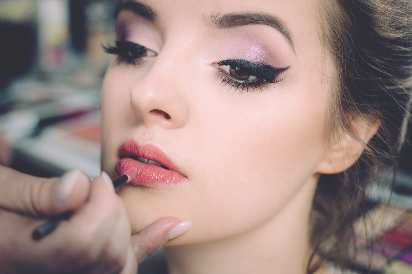 A makeup artist working close-in on a client's eye makeup