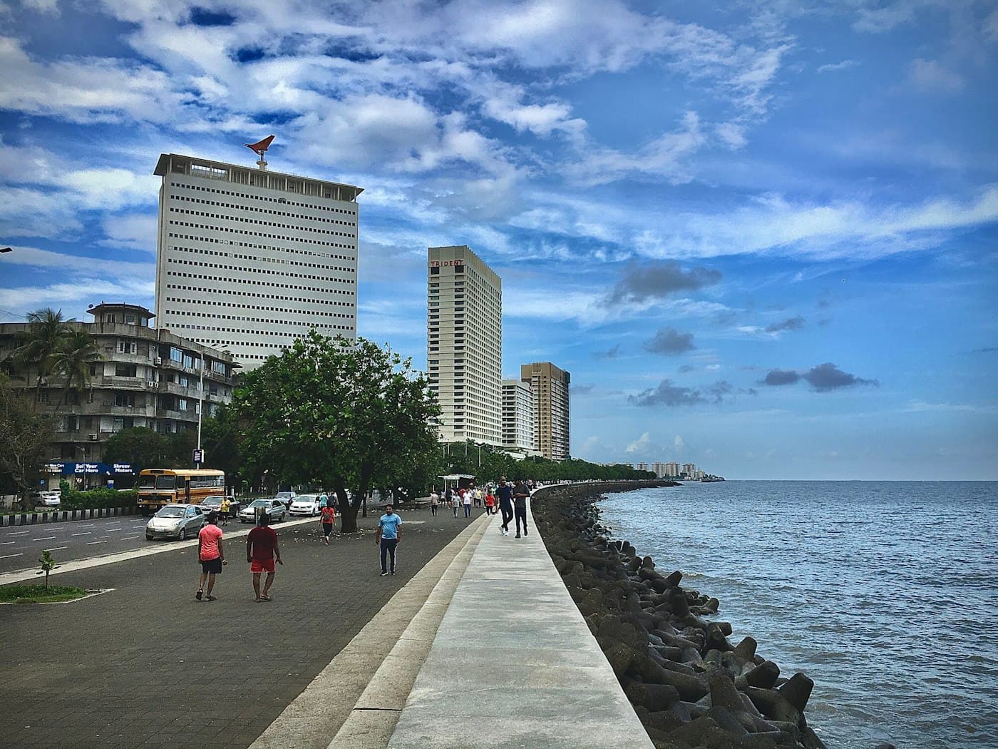 People walking along Marine Drive in Mumbai by the sea