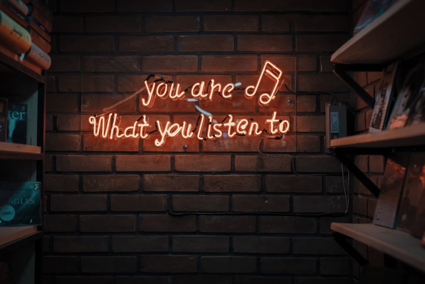 A neon sign reading 'you are what you listen to'