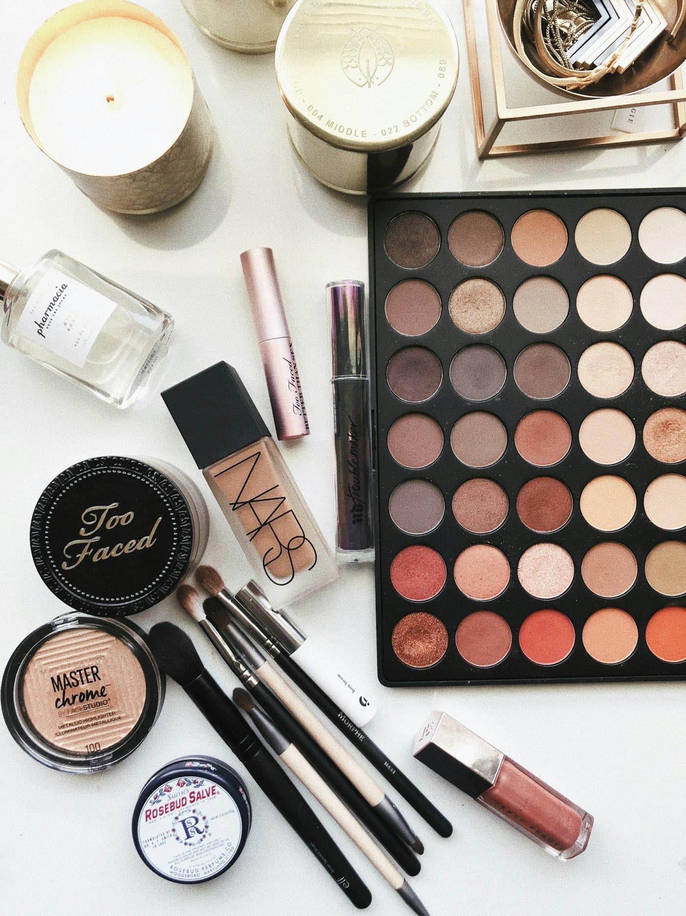 An eyeshadow palette and brushes spread across a table