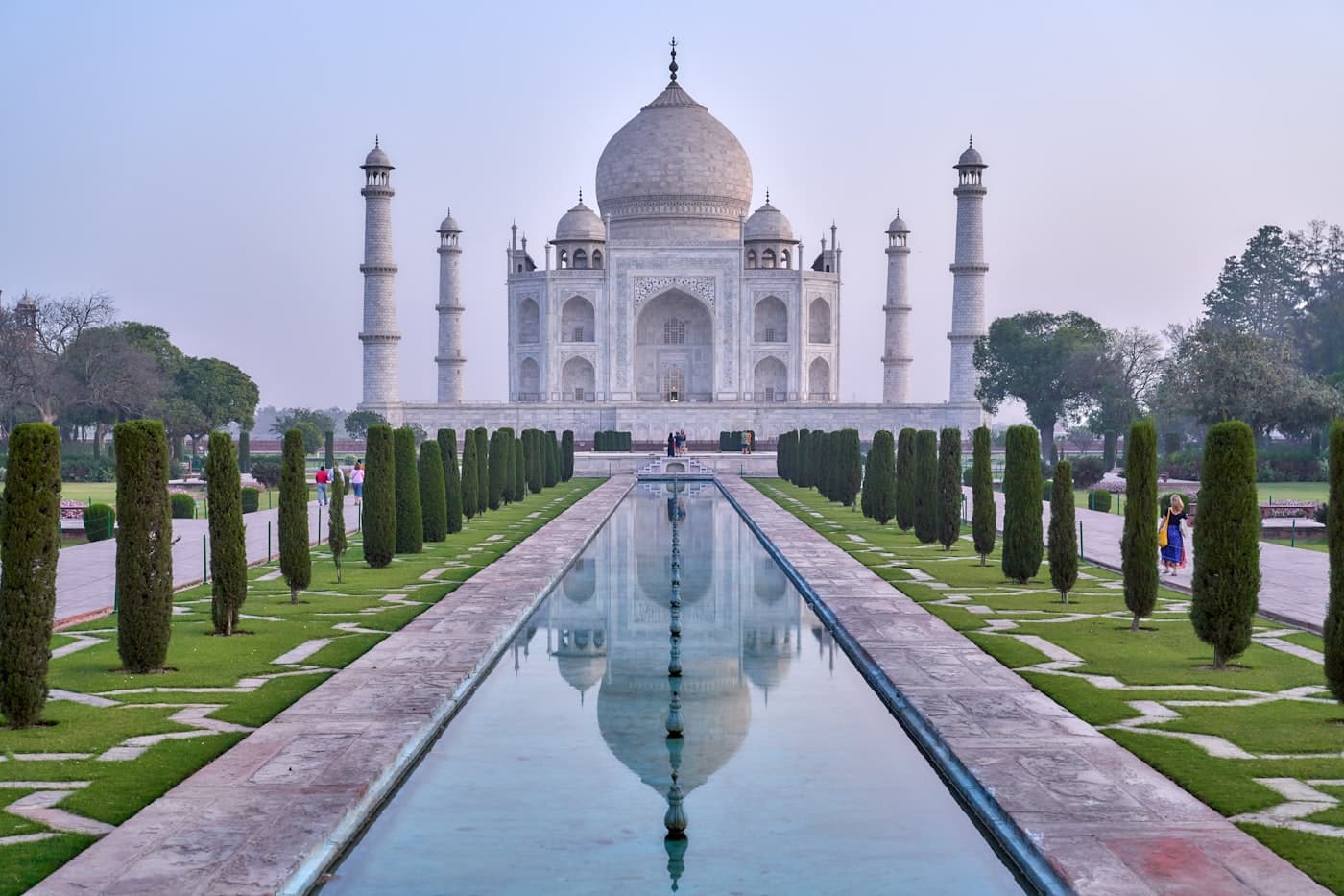 The Taj Mahal reflected in its long pool on a pale morning