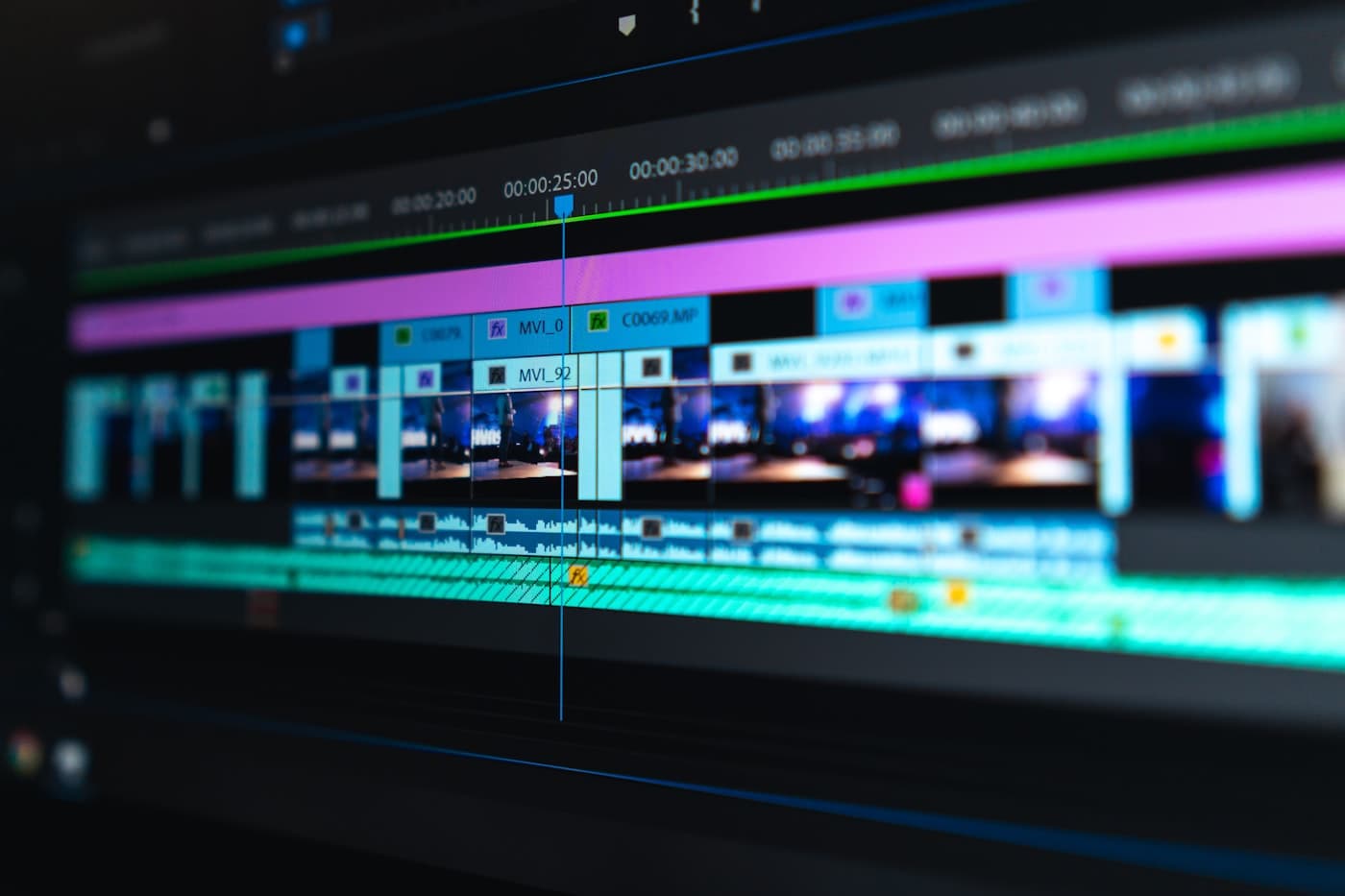 A video editing timeline glowing on a screen in a dark room